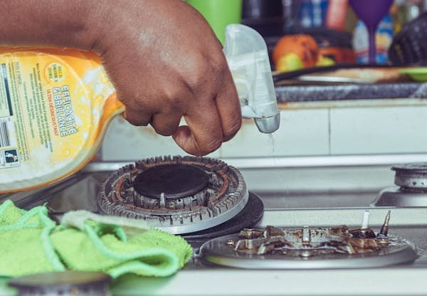 Person cleaning kitchen stove